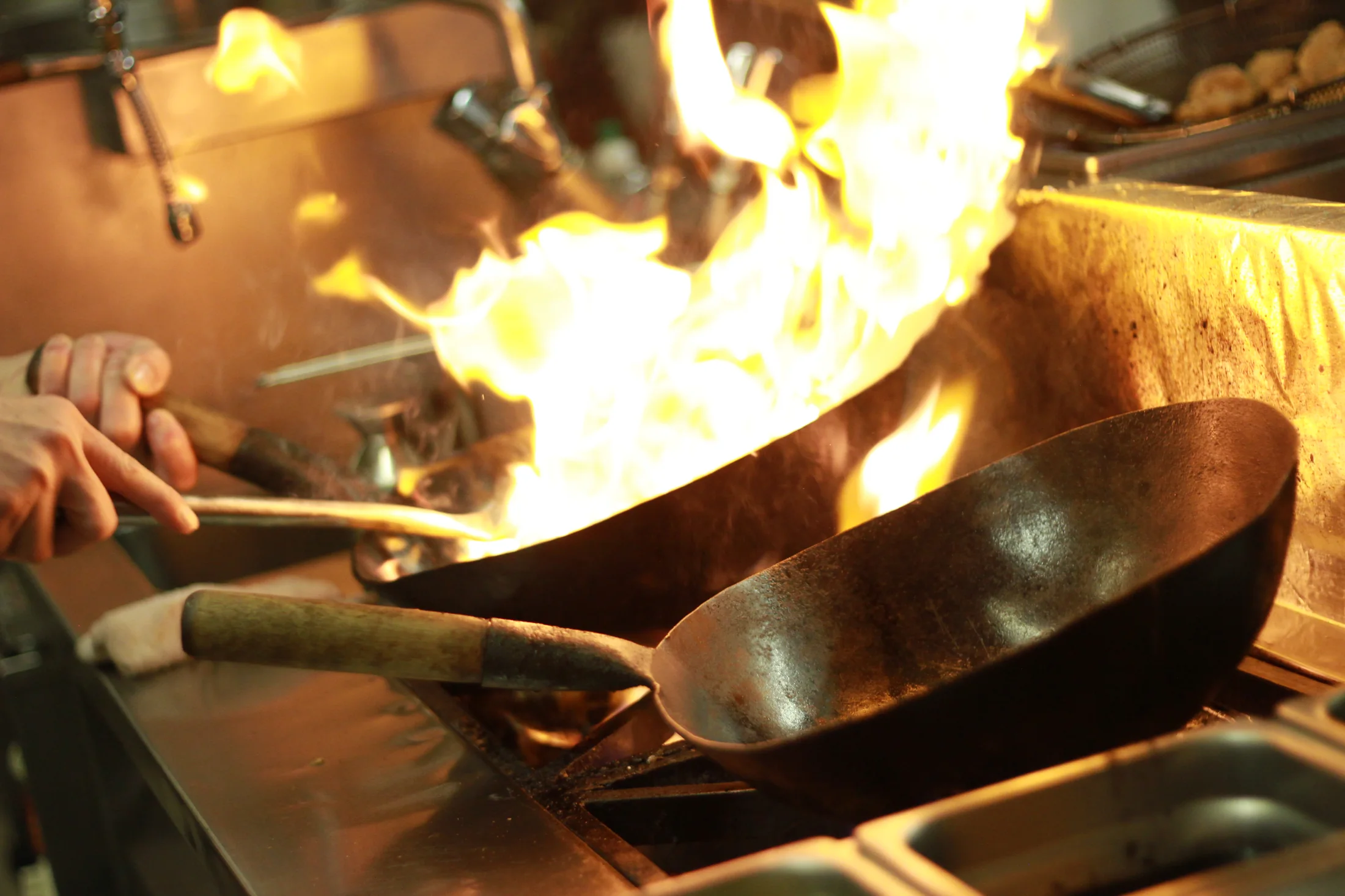 Cuisson au wok dans la cuisine de Kwong Ming